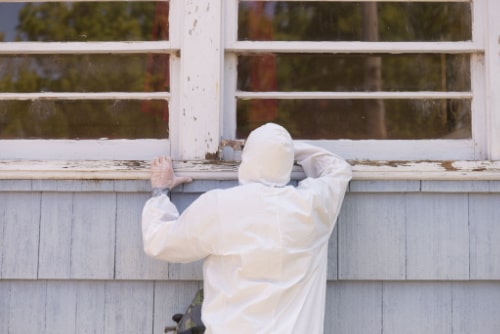 All Clear Environmental Staff In Hazmat Suit Removing Lead Paint On Outdoor Windows